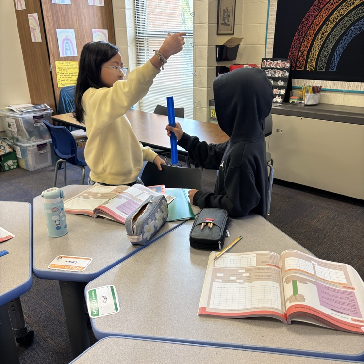 students holding a ruler and object