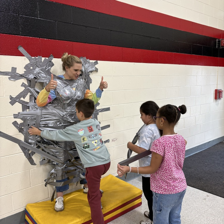 Principal taped to wall