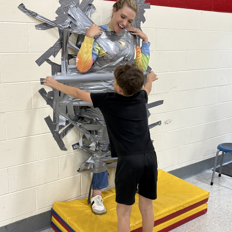Principal taped to wall