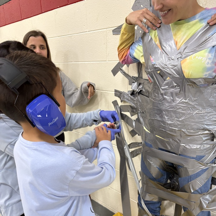 Principal taped to wall