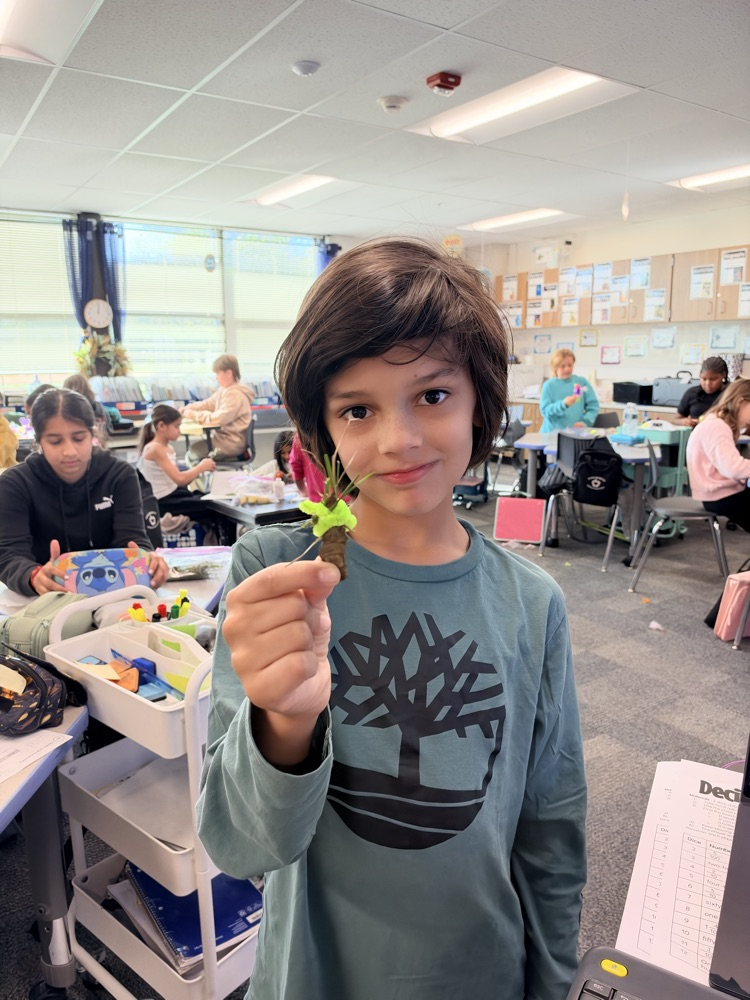 student with a tree craft