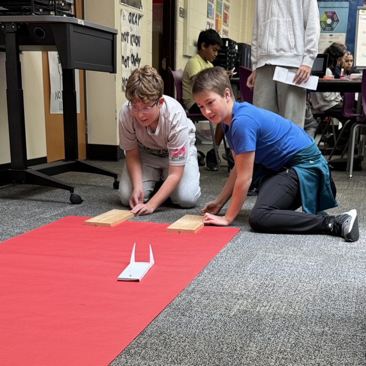 two boys on floor flying airplane
