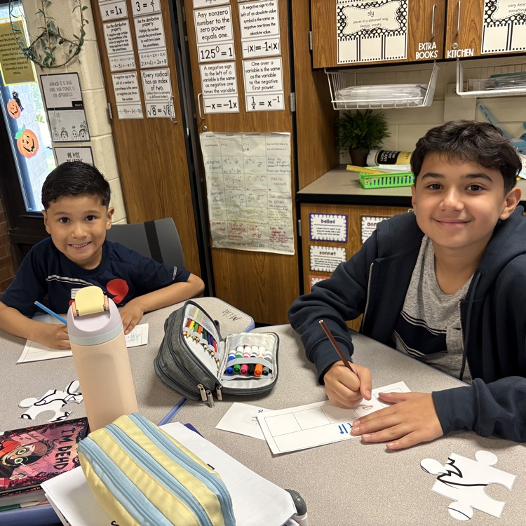 Two students from kindergarten and 6th grade working together. 