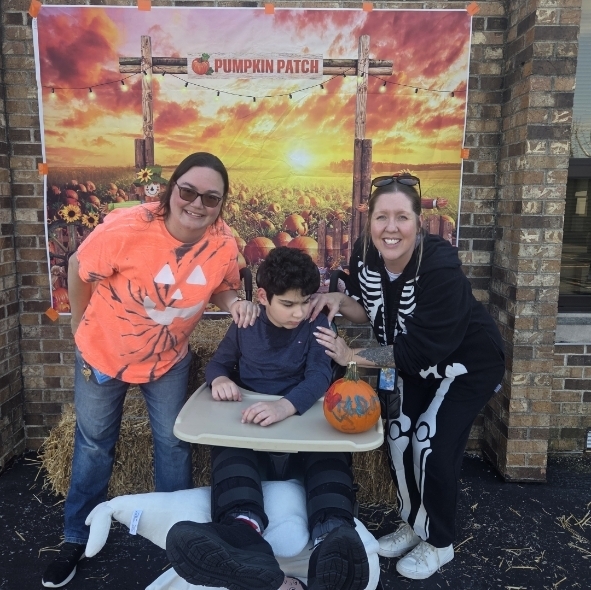boy in a wheelchair with two teachers