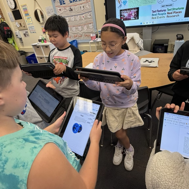 students looking at writing in a Chromebook