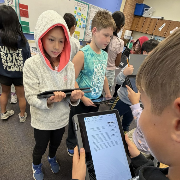 students looking at writing in their Chromebook