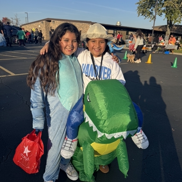 2 girls in a stich costume and a dinosaur costume 