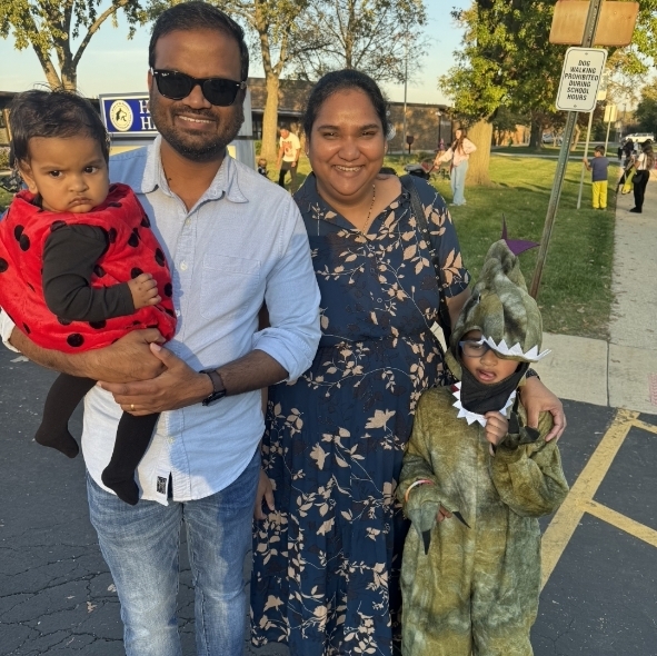 family smiling outside and trunk or treat