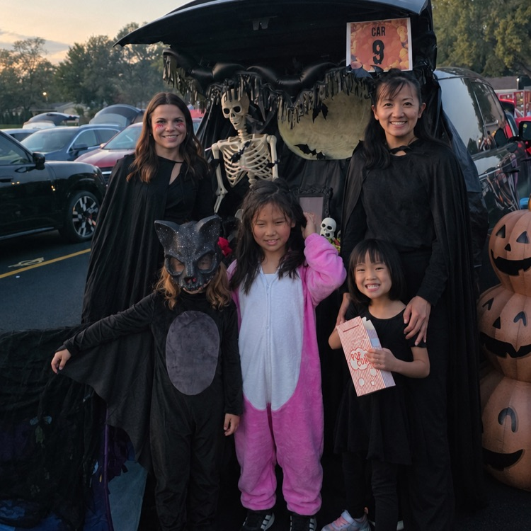 family standing in front of a decorated Halloween trunk
