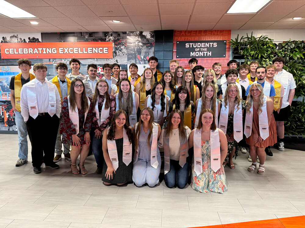 Large group of students wearing stoles and posing for a group photo.