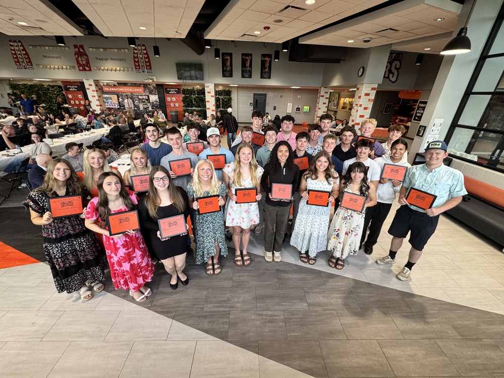 Group of students holding up plaques