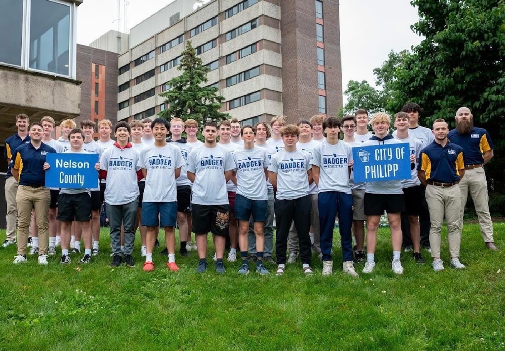 Large group of boys and counselors posing on a lawn