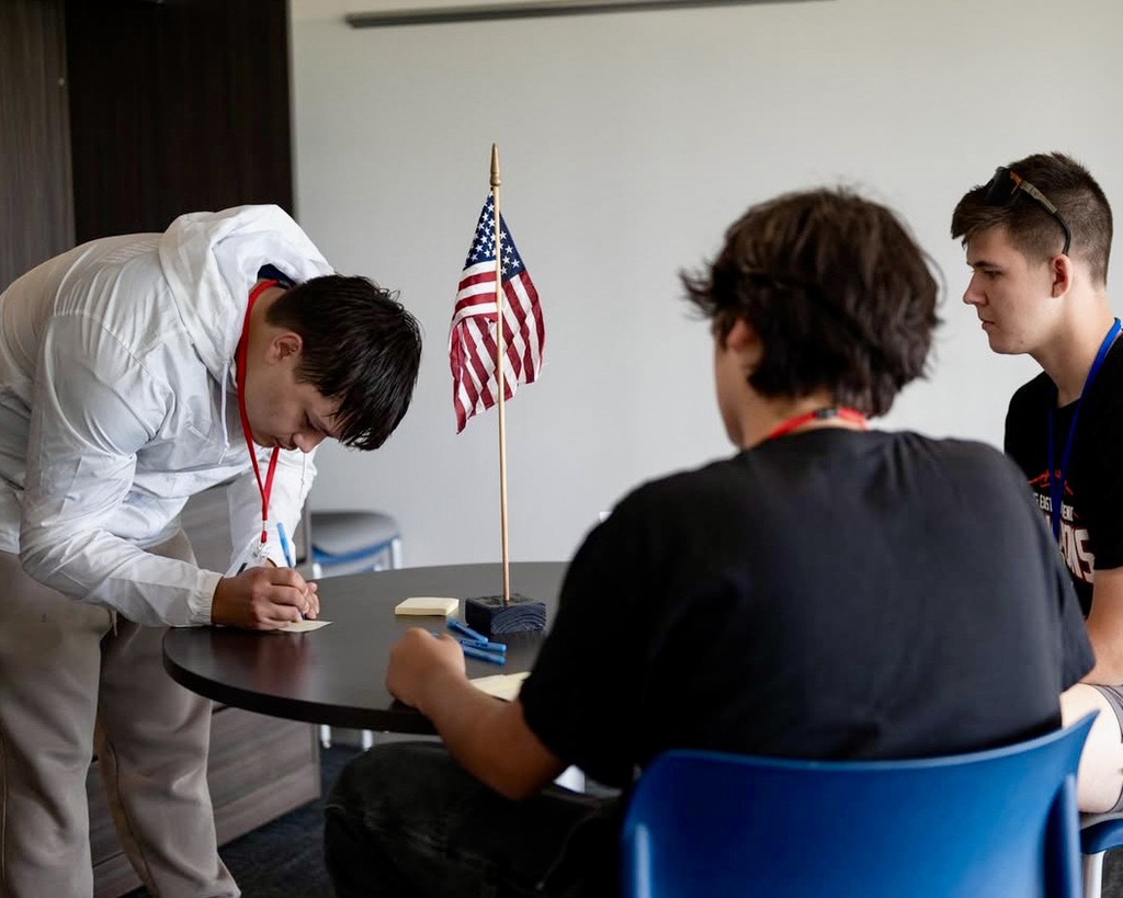 Boy signs a paper.