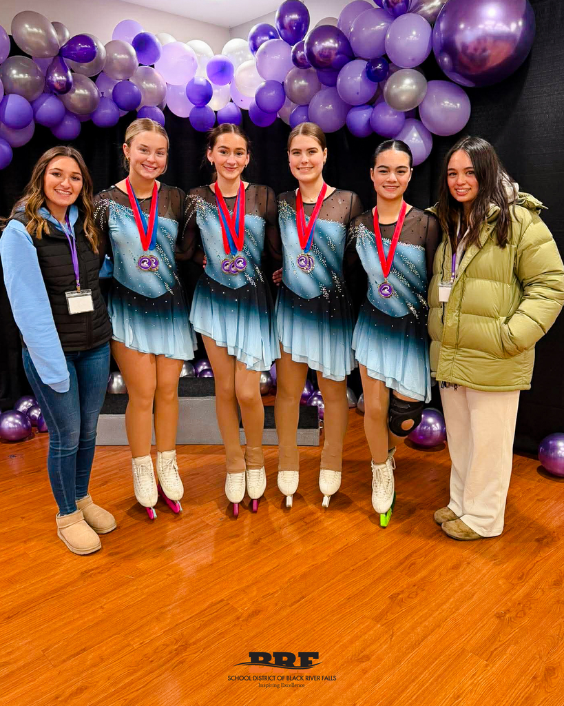 Skaters pose in a row with their coaches on each end.