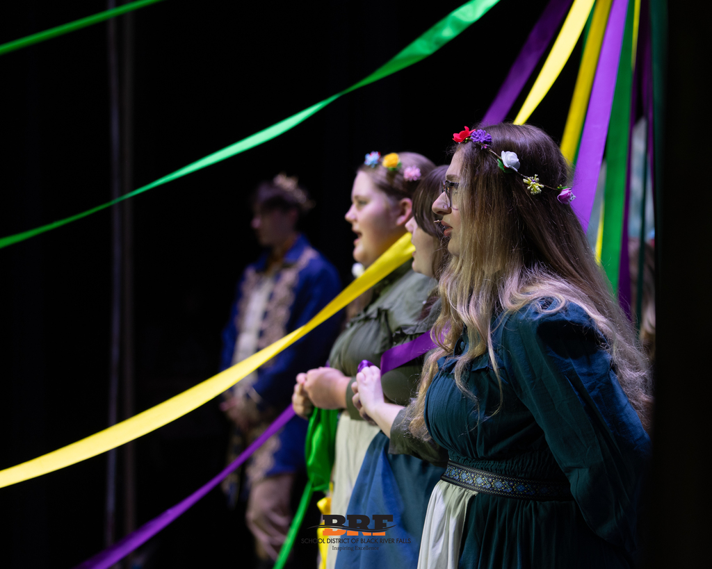 Girls sing on stage.