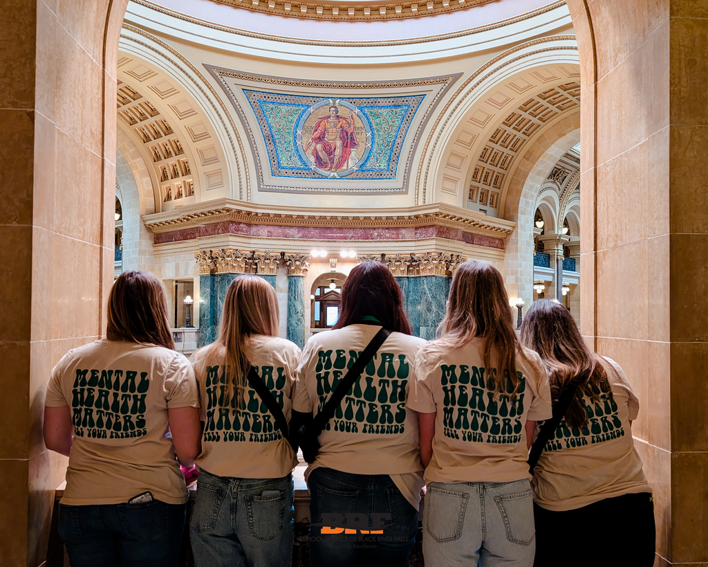 Five students looking out over the inside of the Capitol. 