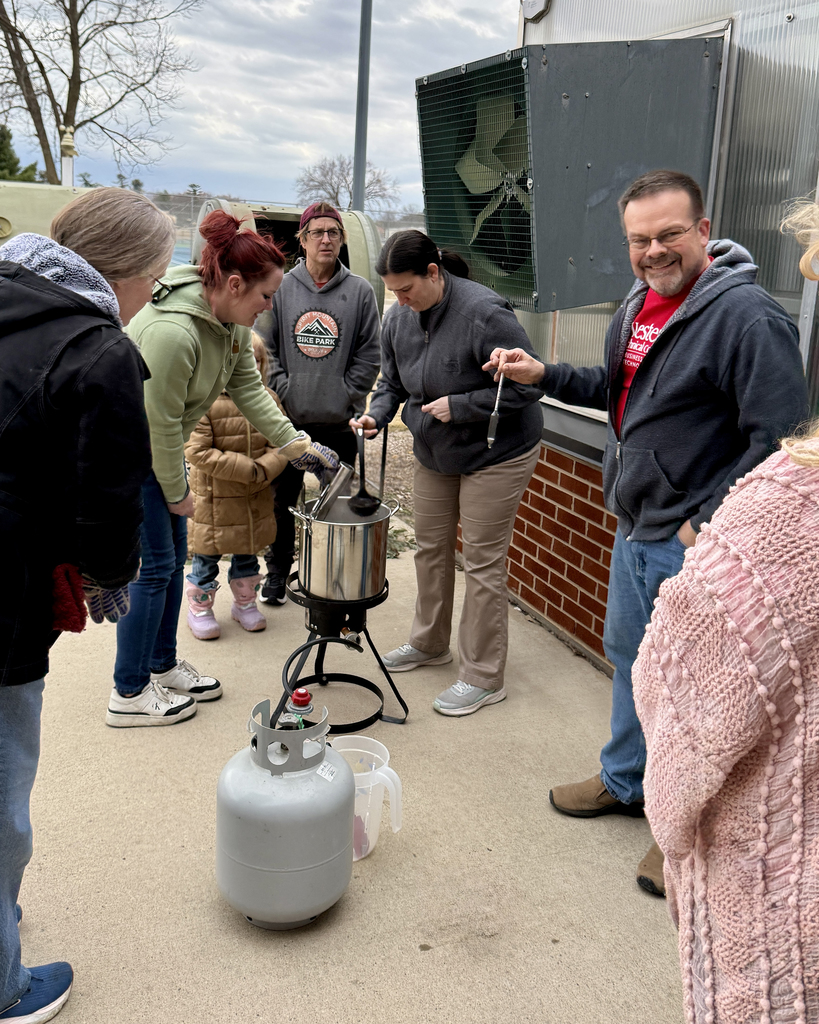 People stand around a boiling pot