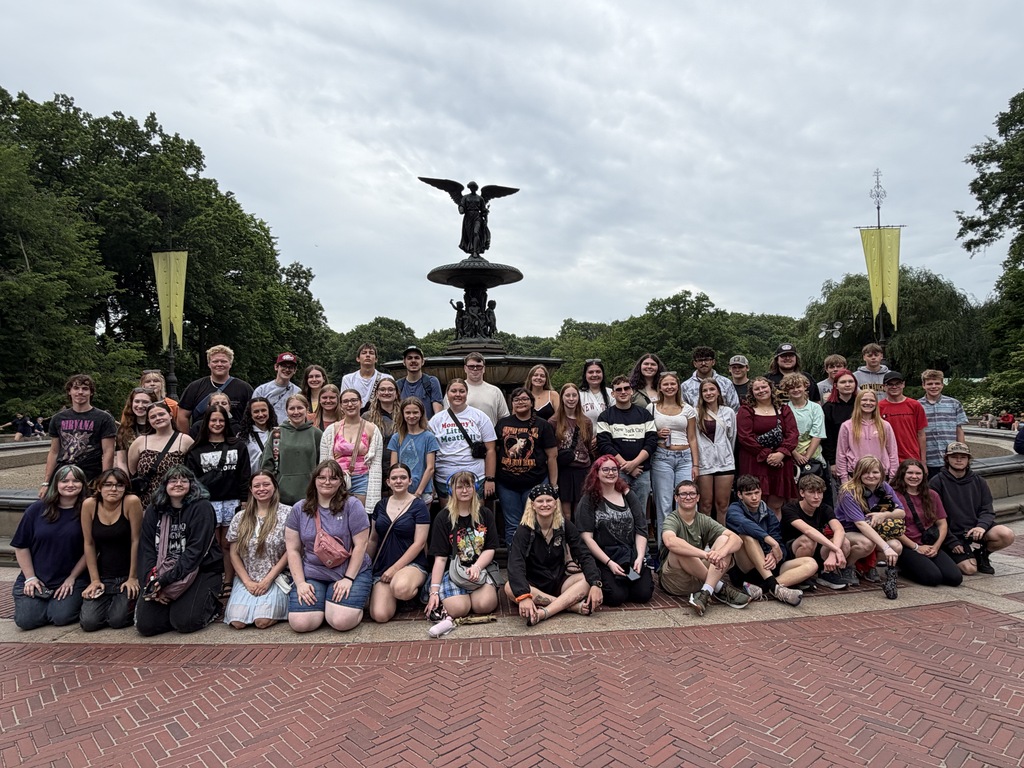 Large group of people stand in front of a fountain
