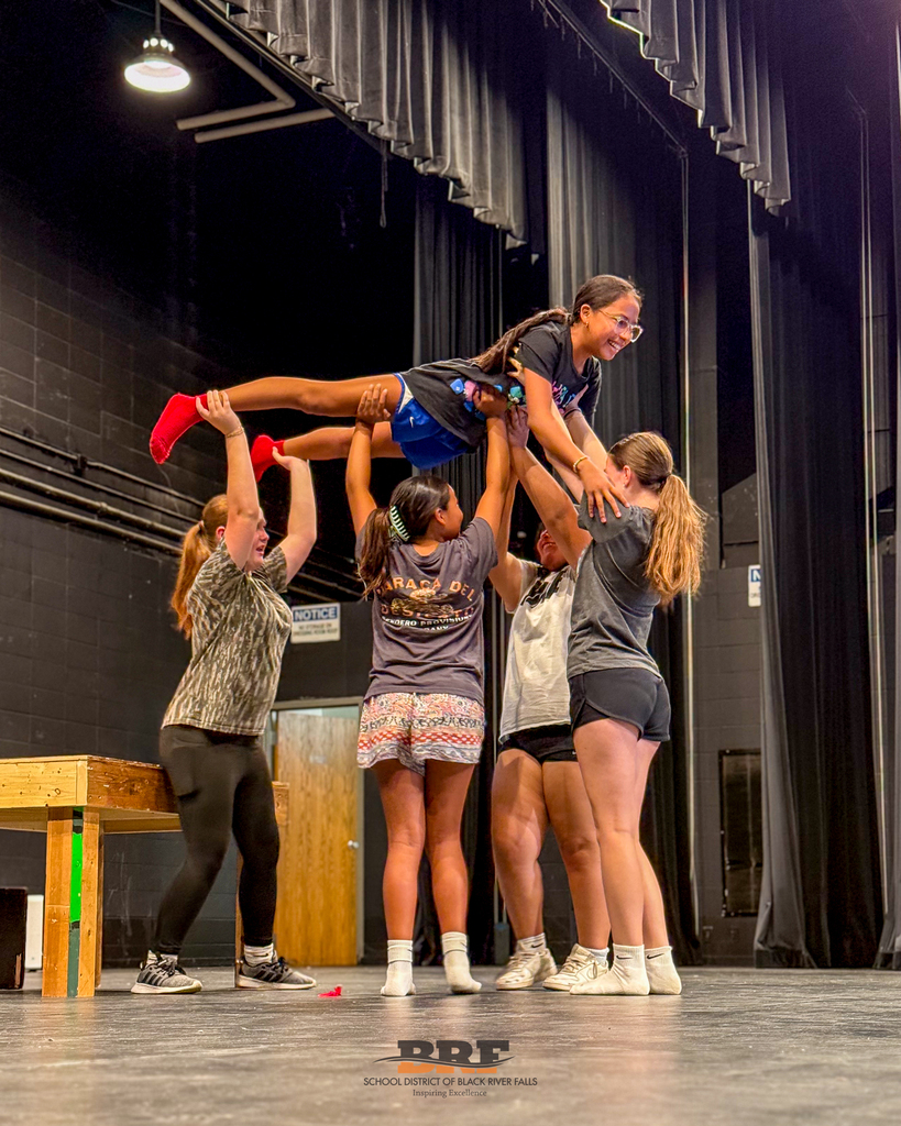 Four girls holding another girl above their heads.