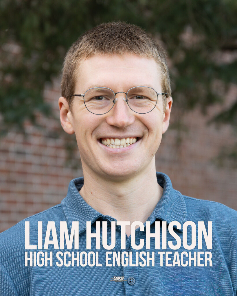 Liam Hutchison, high school English teacher. Portrait of a man in a blue shirt.