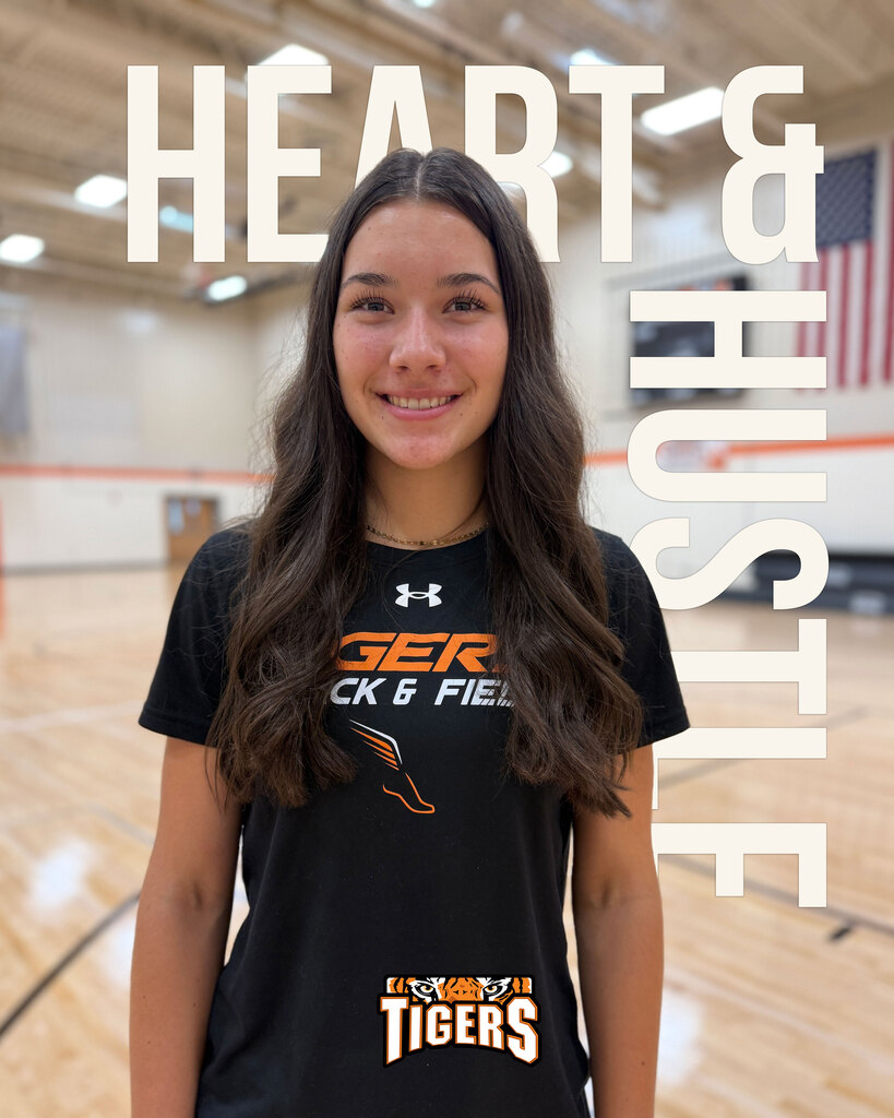 Photo of girl standing on a gym floor. Text on image: Heart & Hustle.