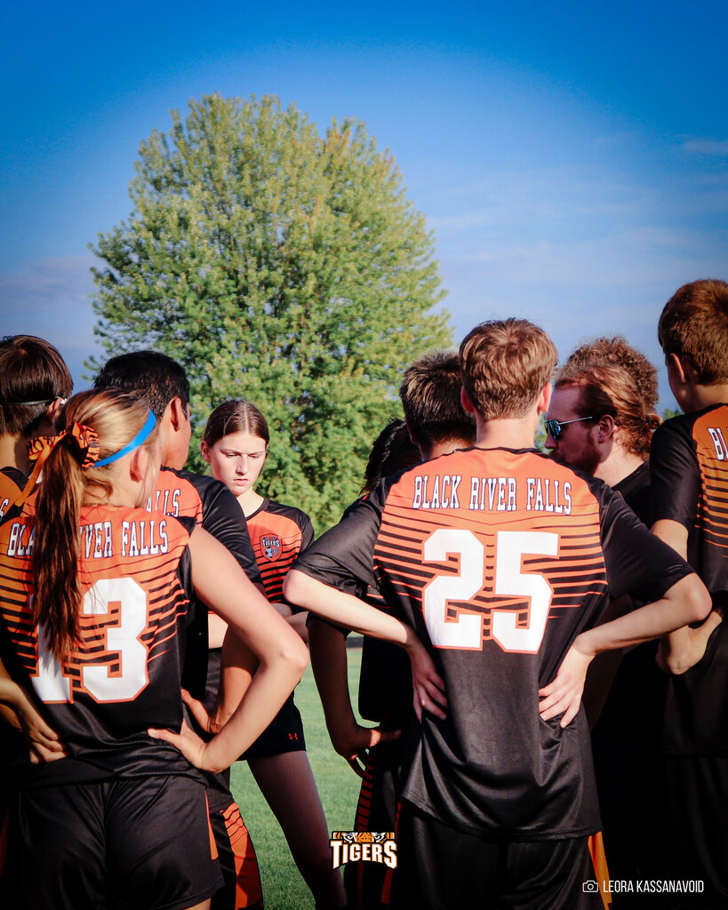Soccer players huddle up at a game.