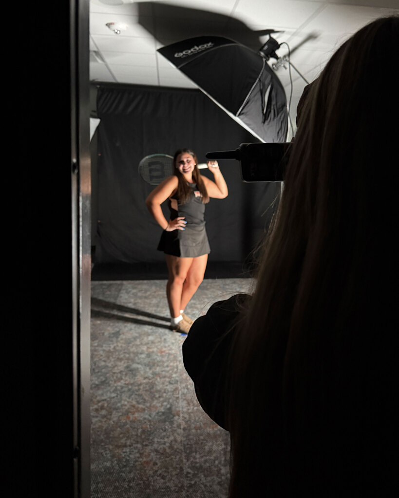 Student takes a photo of a tennis player in a studio