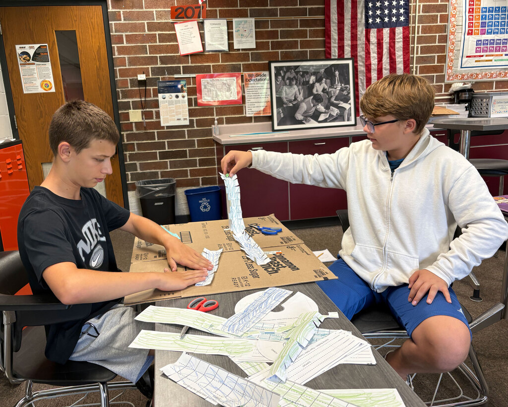 Two students work at a table.
