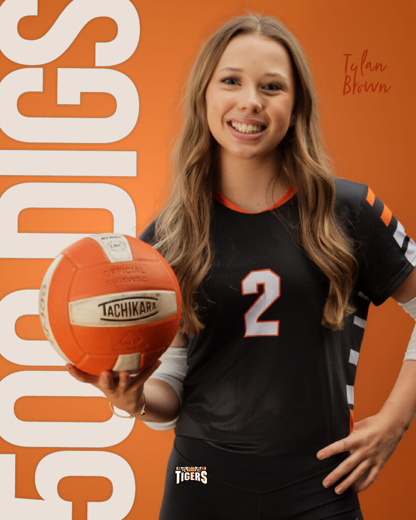Graphic graphic celebrating high school volleyball player Tylan Brown. Tylan smiles while holding a volleyball in her right hand, wearing her black and orange number 2 jersey. Large vertical orange text on the left reads "500 DIGS" alongside the Tiger logo.
