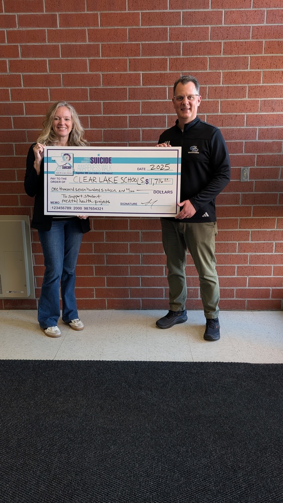 man and woman holding a giant donation check
