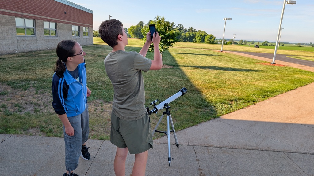 boy looking through phone into sky