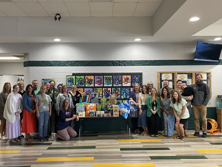 Elementary staff with window store owners and donation
