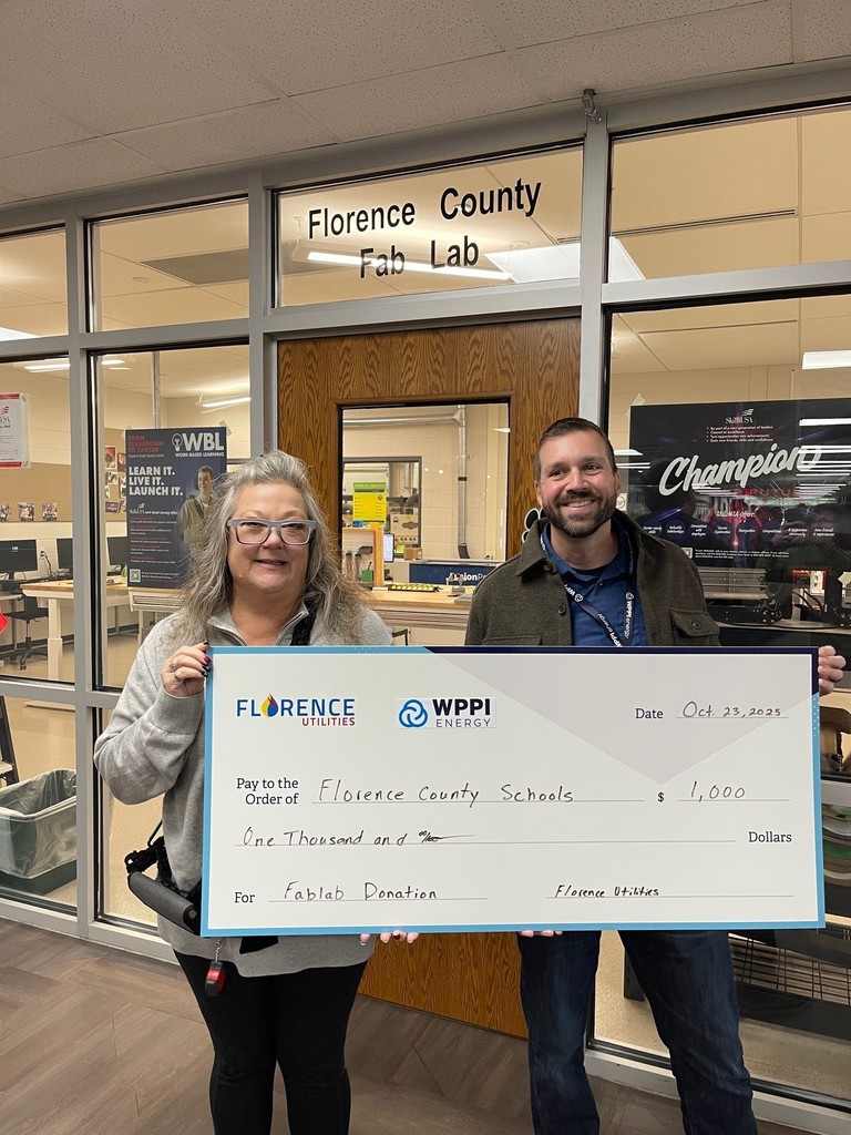 Bonnie Gajewski - Florence Fab Teacher and Jesse - Florence Utility Representative holding a big check for $1000