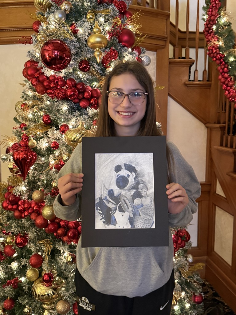 Mikayla Wolf in front of the Christmas Tree with her art piece