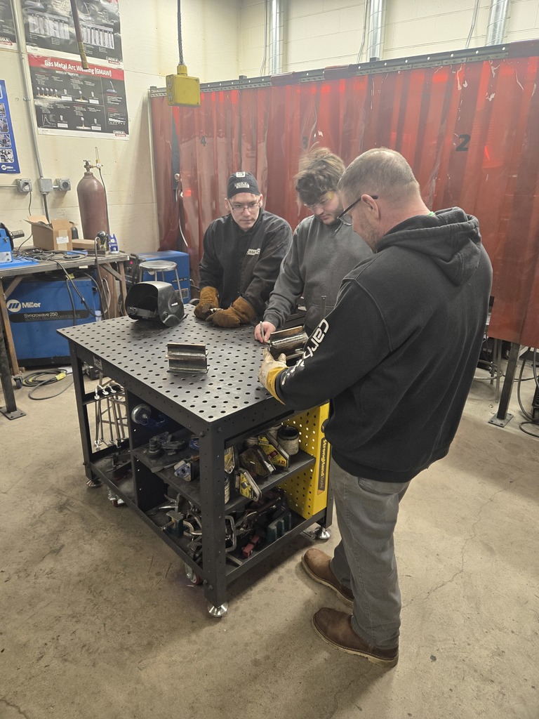 Florence students with NWTC rep inspecting their welds