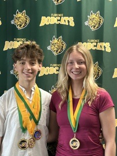 Ashlyn Van Den Heuvel and Jackson Korff In front of a green and gold bobcat banner