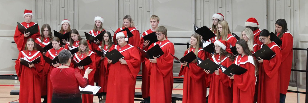 students in red robes singing