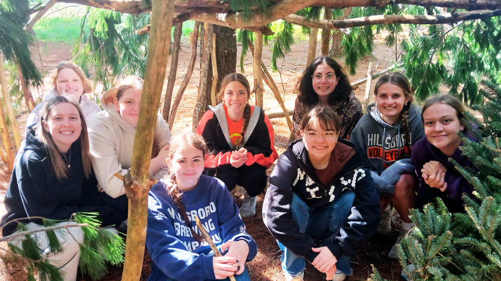 Students pose in makeshift shelter