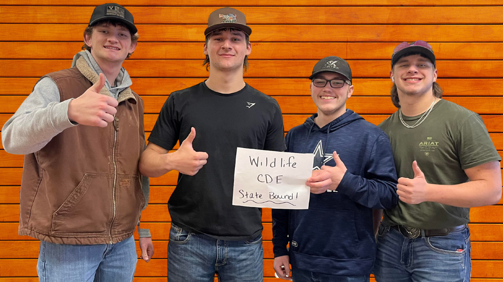 Four students hold "state bound" sign for Wildlife CDEs