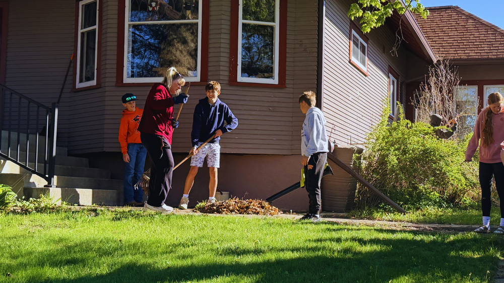 Students and staff clean outside of house