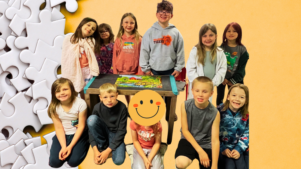 First Graders pose with their completed puzzle