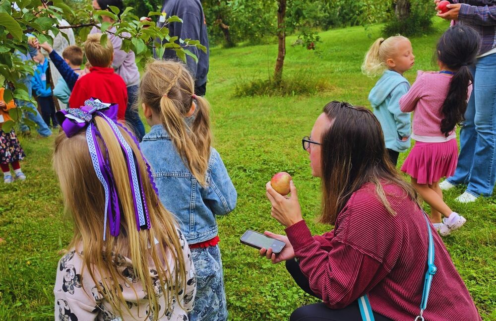 Students stand in apple orchard