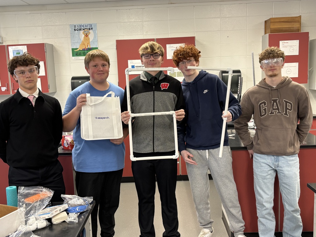 Students hold "6,7" in physics class.
