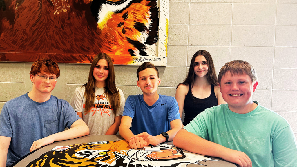 Students pose at cafeteria table for ACT achievement