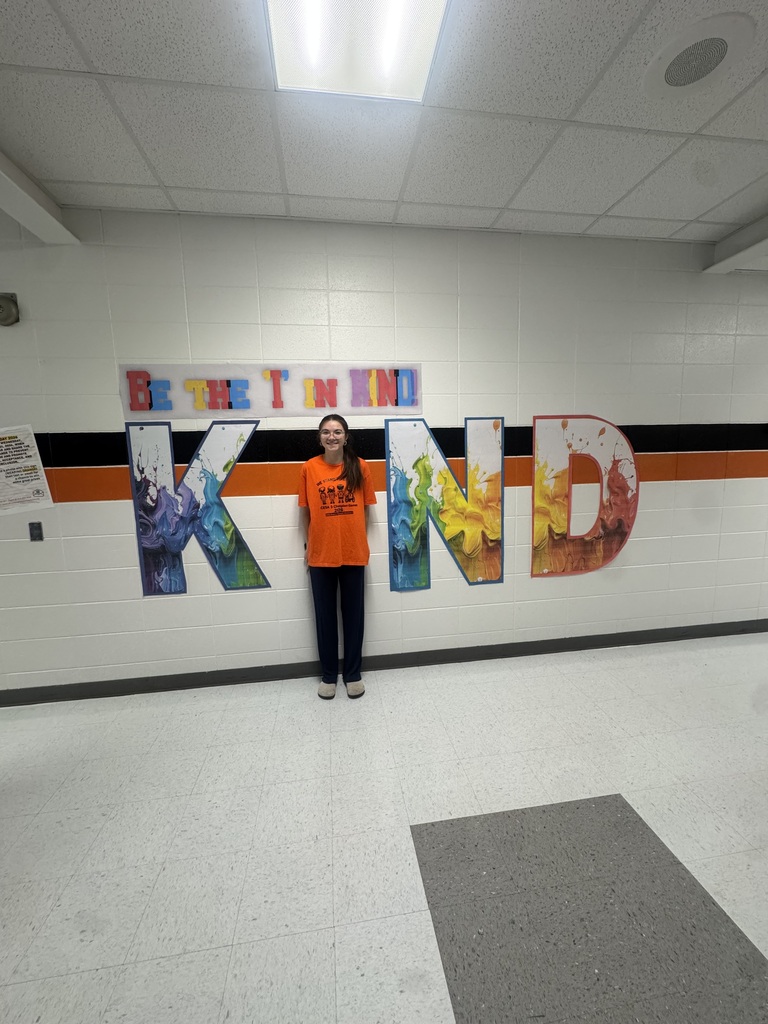 Student wears orange, poses with Kind sign.