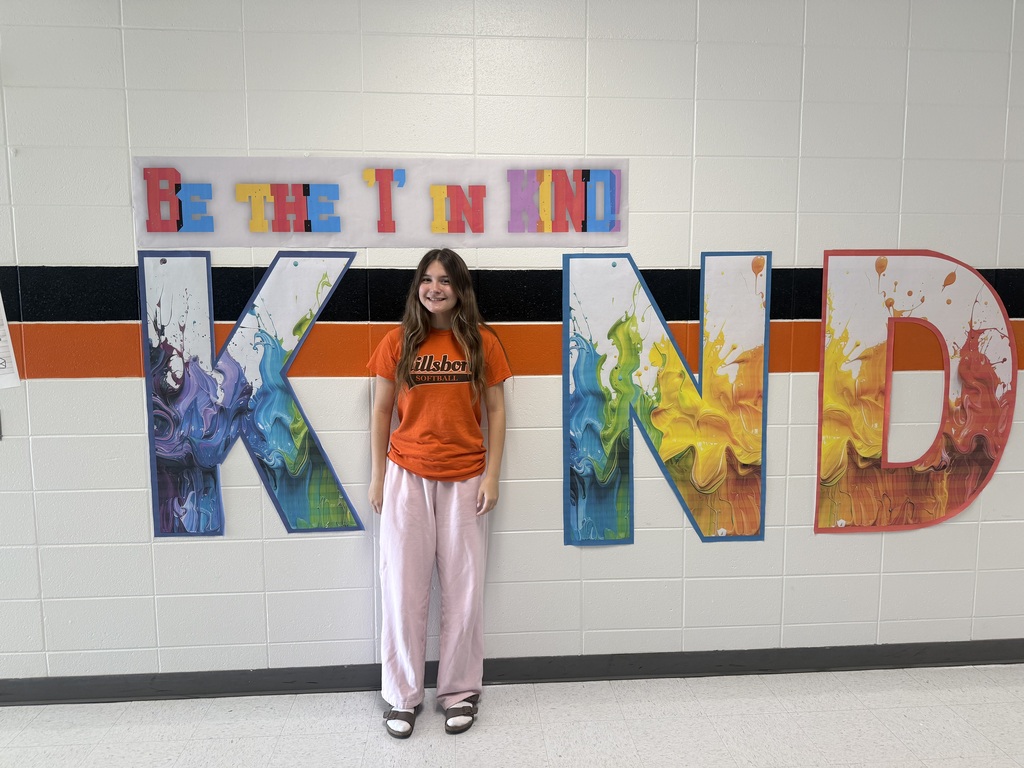 Student wears orange, poses with Kind sign.