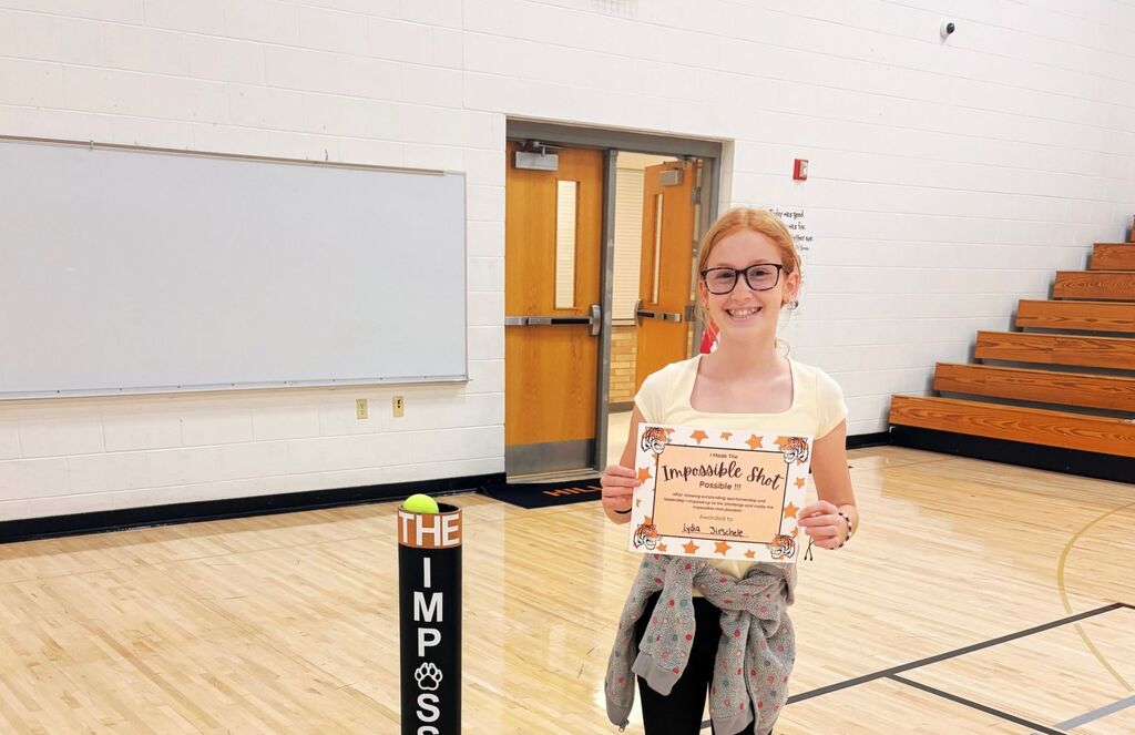 Lydia makes the impossible shot and poses next to her shot.