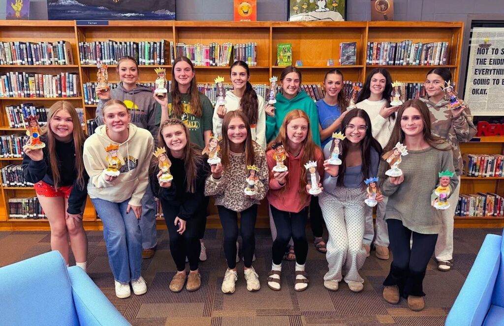 Students pose with bobbleheads