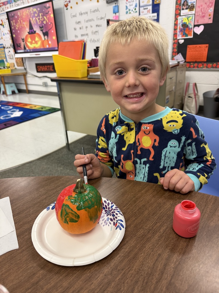 student paints pumpkin