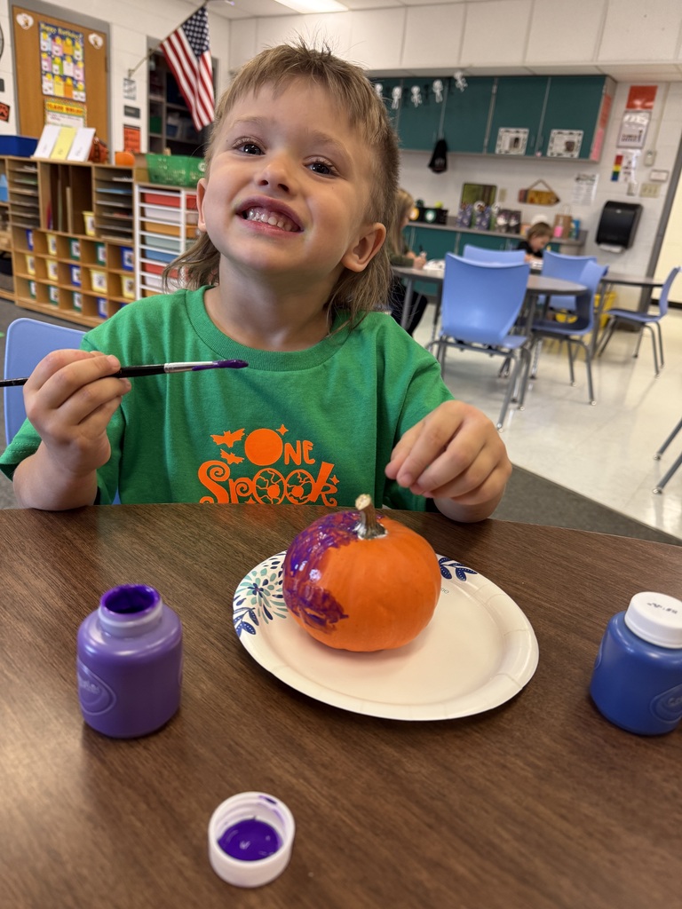 student paints pumpkin